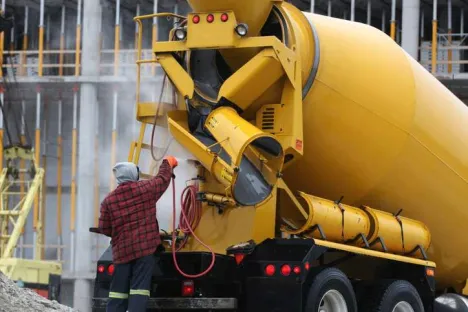 Homme lavant une bétonneuse sur un chantier avec de l'eau au pH régulé par injection de CO₂ (Nexelia™)