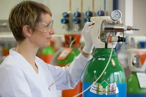 Technicienne de laboratoire manipulant une bouteille ALPHAGAZ™ 2 d'argon