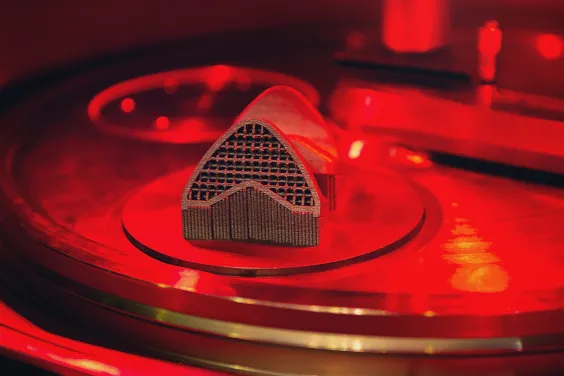 Pièce métallique issue de fabrication additive sur son plateau d'impression.