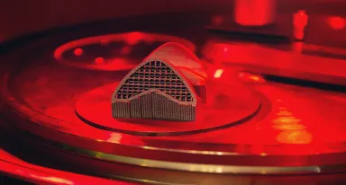 Pièce métallique issue de fabrication additive sur son plateau d'impression.